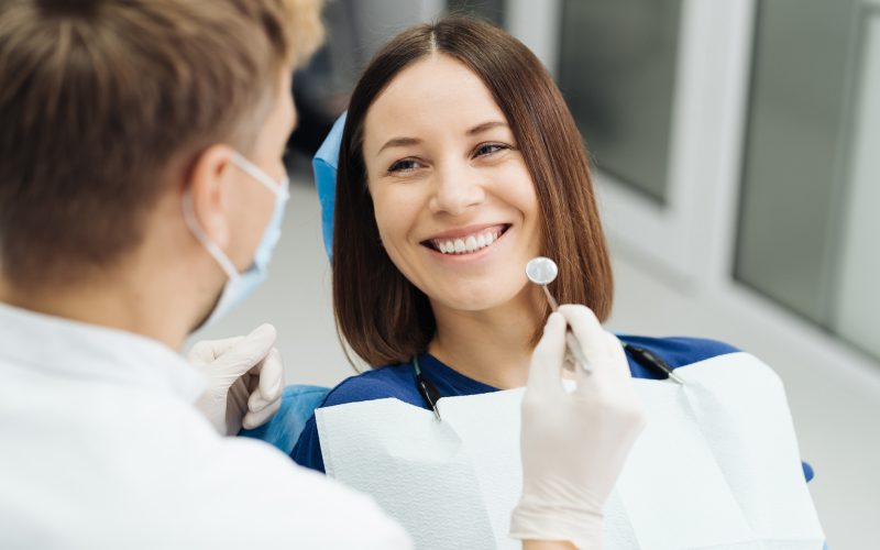 uśmiechnięta kobieta na wizycie stomatologicznej