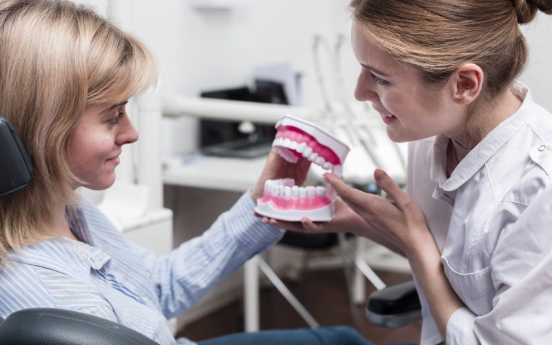 dentystka pokazująca model zębów pacjentce